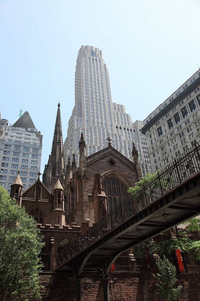 Een foto van een traditioneel kerkgebouw met daarachter wolkenkrabbers die tot ver in de hemel reiken.