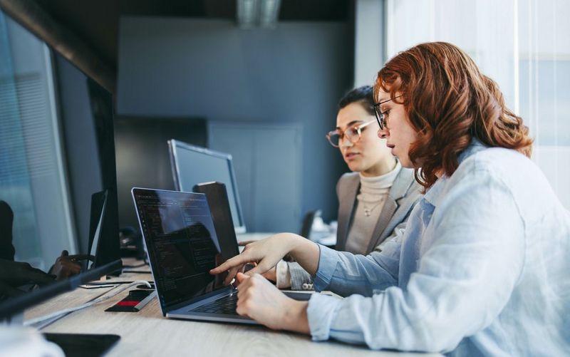 Two people looking at a laptop 