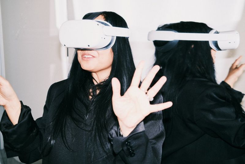A woman, Jean Jarvis, uses a headset to view VR content