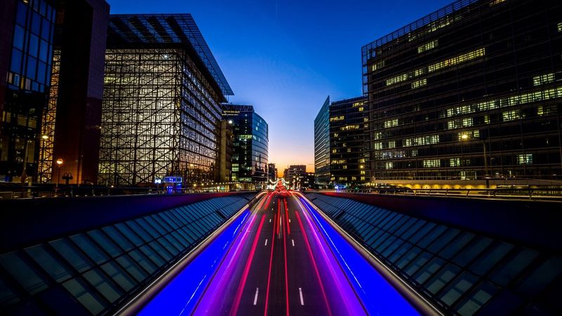 Long exposure cityscape at dusk with red and blue car light trails.