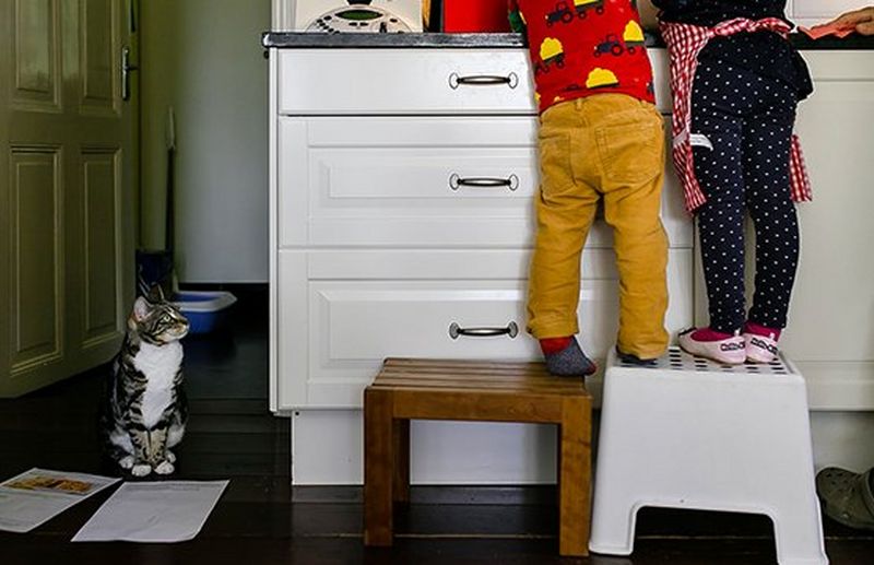 children stand on stool in kitchen