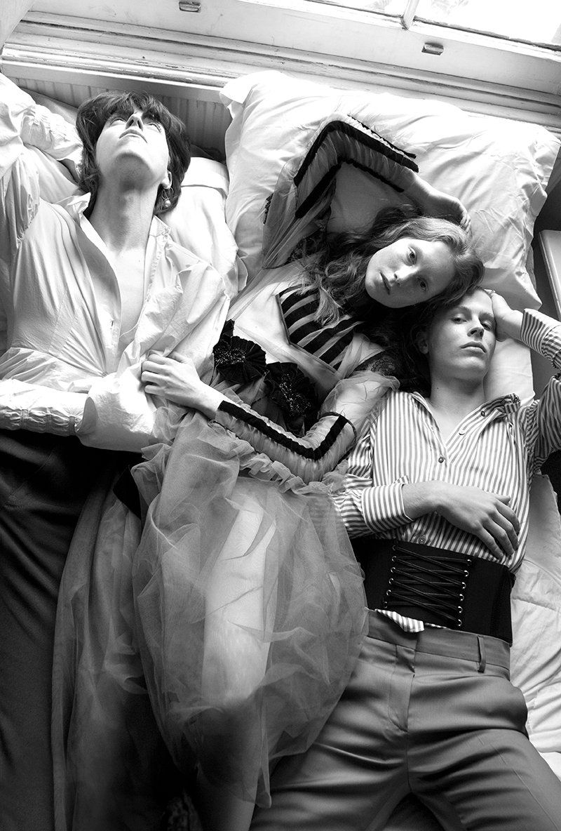 Three young people relaxing on a bed