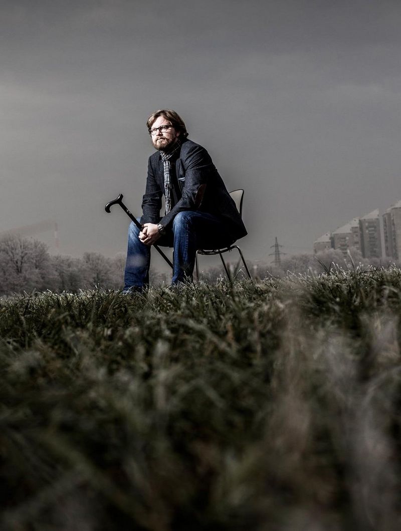 man sitting on chair in a field
