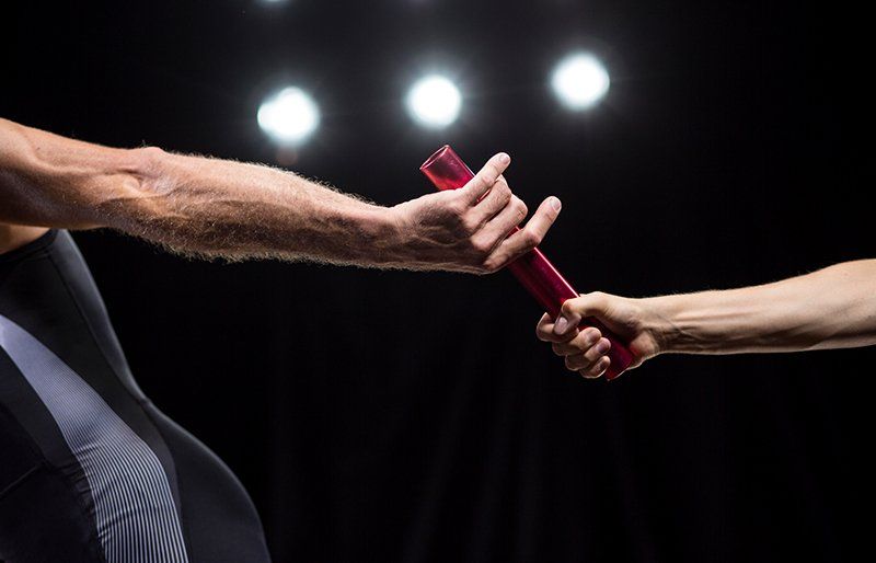 Image of a group of photographers capturing live sport action beside audiences. 