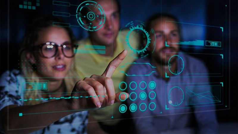 Computer programmers examining data on futuristic screen