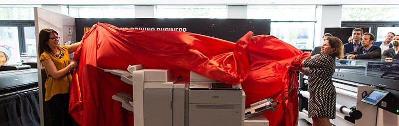 Sara reveals a new product to a group of customers