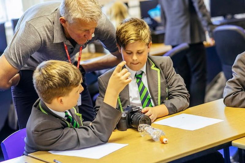 Two boys taking image of water bottle