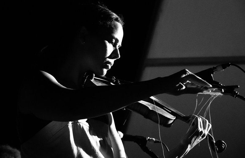 Rhiannon Giddens playing a violin as her bow started to denigrate
