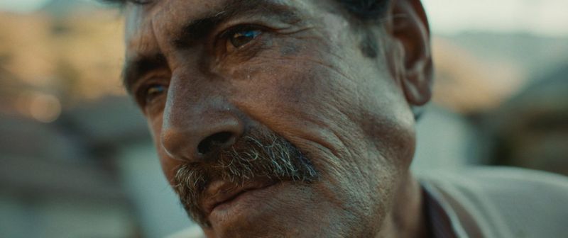 A film grab showing a close of up a Venezuelan man's face showing the detail in his moustache and wrinkles on his cheek, shot on the Canon EOS C70.