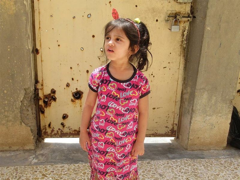 Maryam Raheem Jassem's younger sister in pink dress with 'love' printed across it.