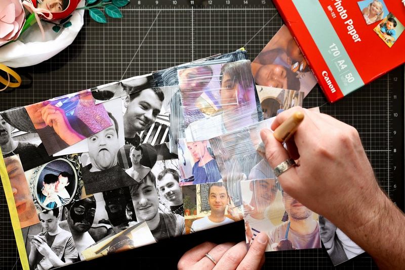 A pair of hands uses a brush to glue down photographs on to the lid of a shoebox using a découpage technique.