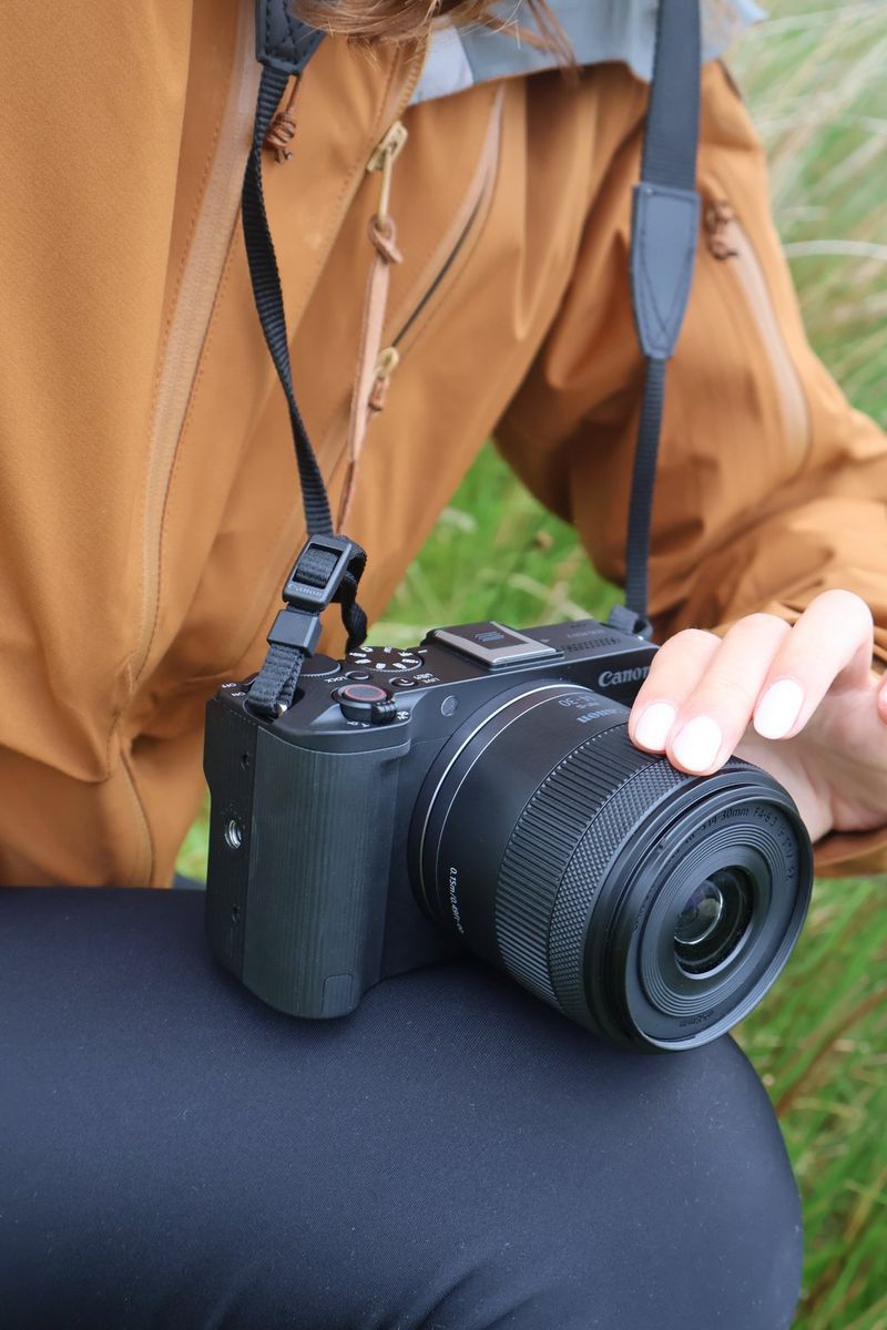 Vlogger Niamh Mackinnon places her fingers on a Canon RF-S 14-30mm F4-6.3 IS STM PZ lens attached to a Canon EOS R50 V.