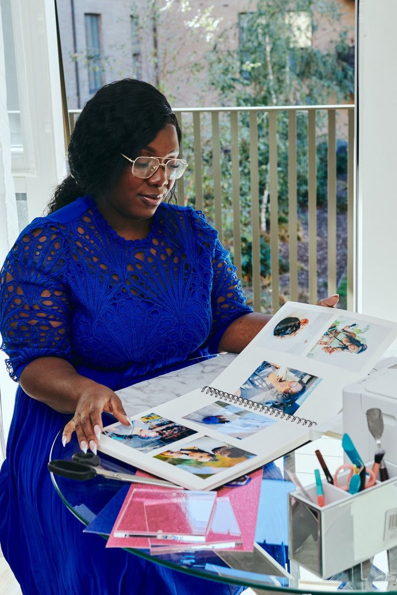 Juliet Amma bladrer gennem et personligt fotoalbum, som hun og hendes datter lavede ved hjælp af Canon PIXMA-printeren på bordet foran hende.