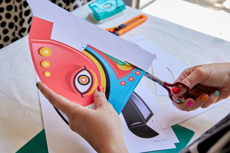 A pair of hands cuts out a bull mask template printed via the Canon Creative Park app. 