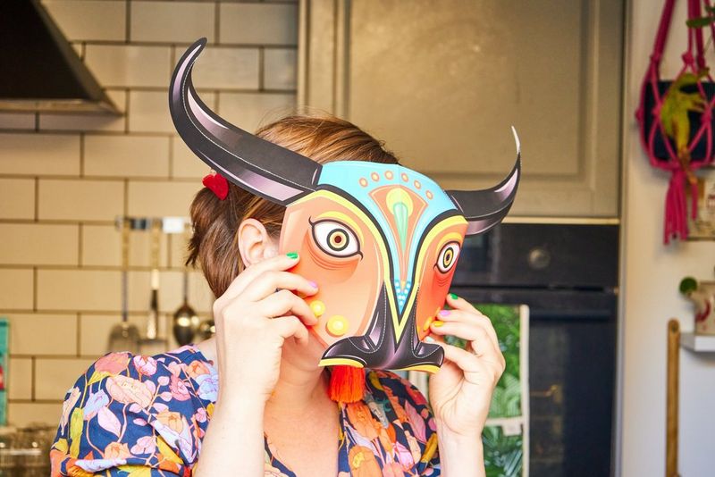 Pippa holds a completed bull mask up to her face.