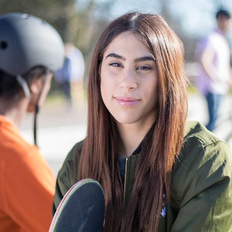 A portrait of a woman at a skate park.