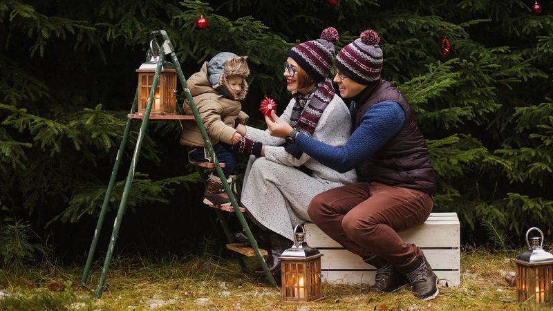 A child sits on a stepladder entertained by his parents.
