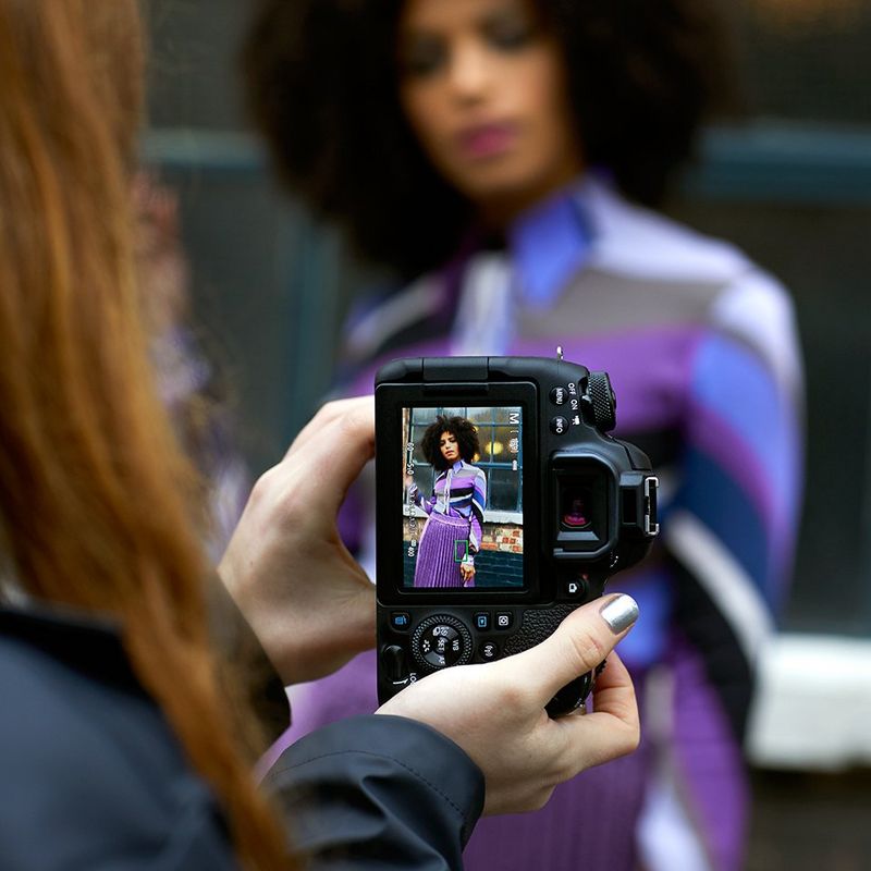 The back of a Canon camera, showing a portrait photo being taken.