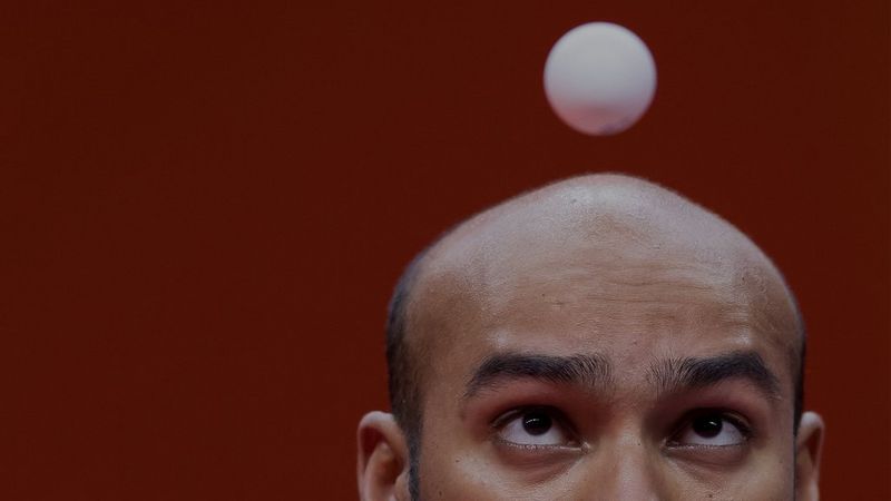 A close-up of table tennis player Rhikesh Taucoory with the ball appearing to hover just in front of his face. Photo by Mark Kolbe.
