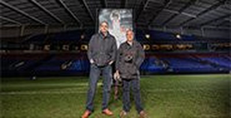Sports photographer Dave Rogers stands next to rugby player Martin Johnson on the pitch.