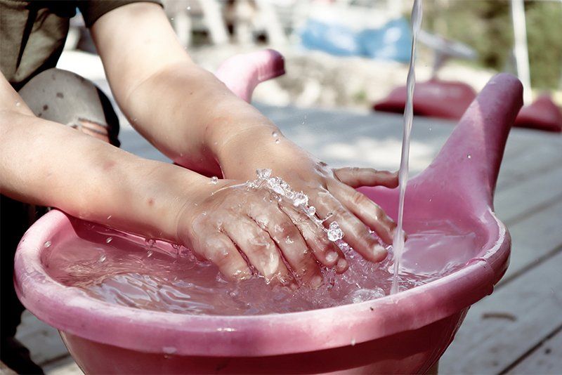 A close-up of someone playing with water, photographed by Hannah Clark on a Canon EOS 250D.