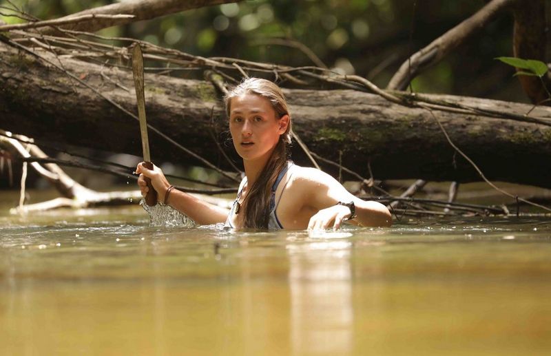 Laura Bingham pictured from behind, facing dense jungle, as she films a vlog with a Canon PowerShot G7 X Mark II.