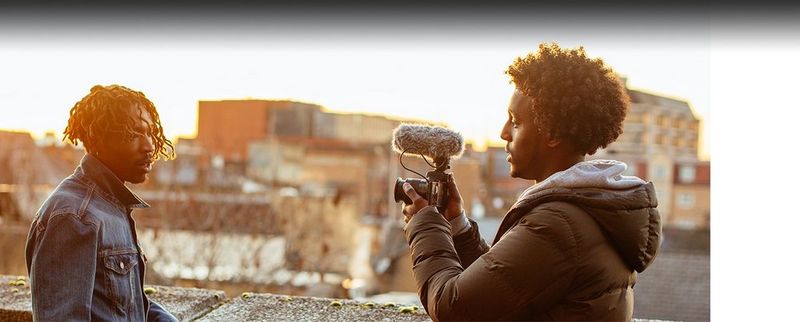 A vlogger holding their camera, using the flip-out Vari-Angle screen to watch their footage.