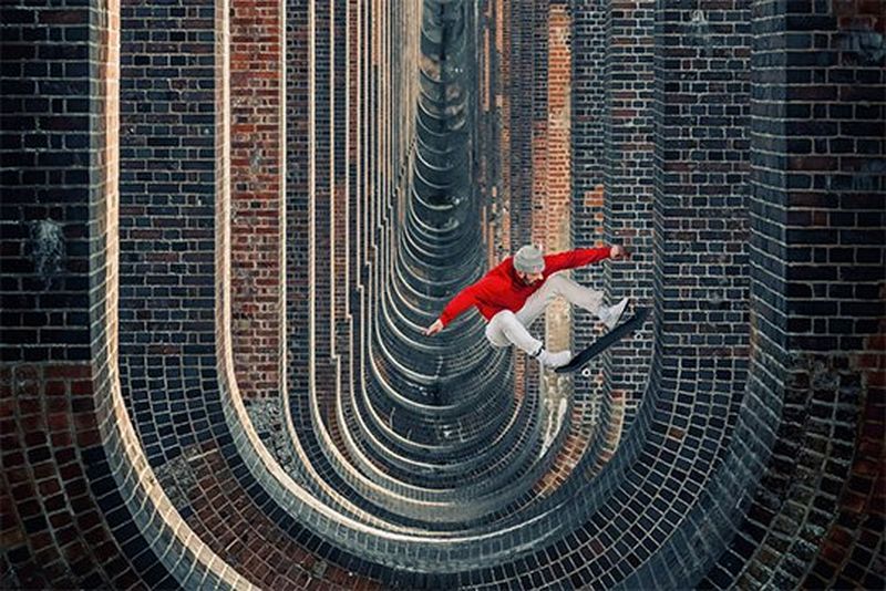 A skateboarder jumps over bridge supports like a skate ramp. Photo by Lorenz Holder using a Canon EF 70-200mm f/2.8L IS II USM lens.