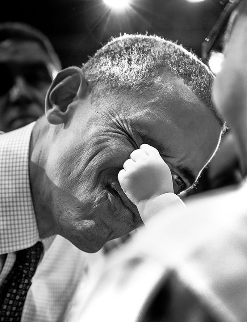 While working the crowd at one of his speeches, Obama meets a baby girl, playfully allowing the child's hand to press against his face.