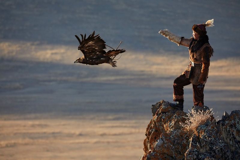 A teenage Mongolian eagle huntress releases her bird of prey. Taken by Alessandra Meniconzi on a Canon EOS 5D Mark IV.