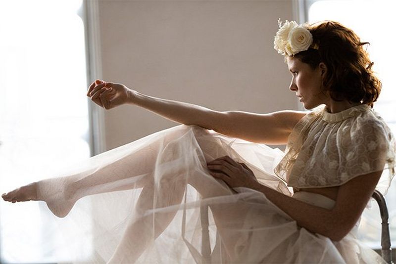 A bride sits in a chair, kicking her legs out. Photo by Félicia Sisco with a Canon RF 85mm F1.2L USM lens.