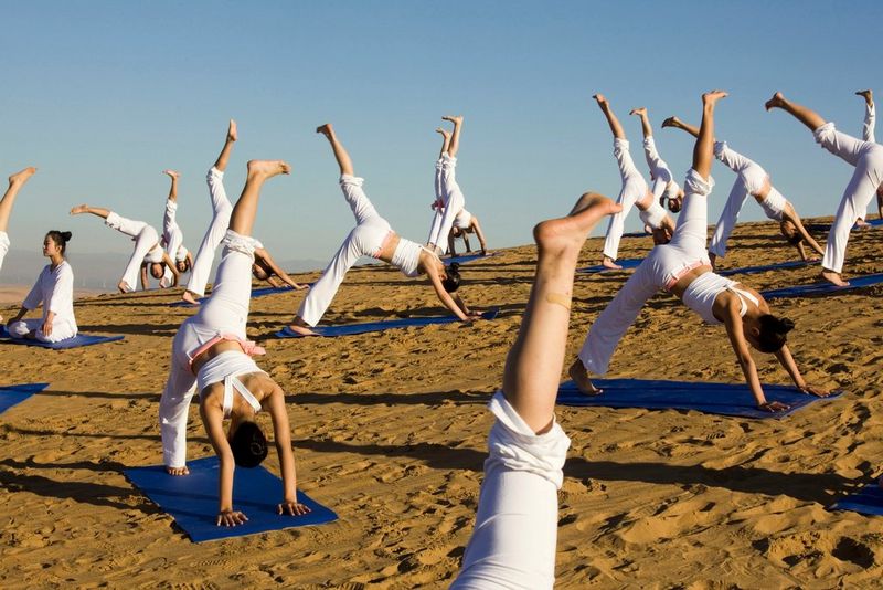 A group of women all wearing white performing yoga on a sand dune in the Kubuqi Desert in China's Inner Mongolia Autonomous Region.