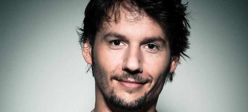A Canon EOS R camera, mount adapters and RF lenses sit on a black surface in front of a black background.