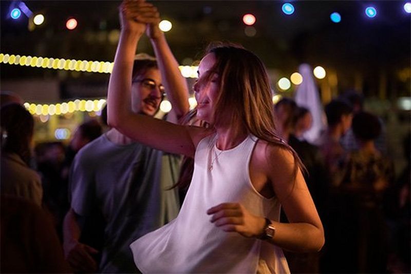 A woman in white is twirled by her dance partner.