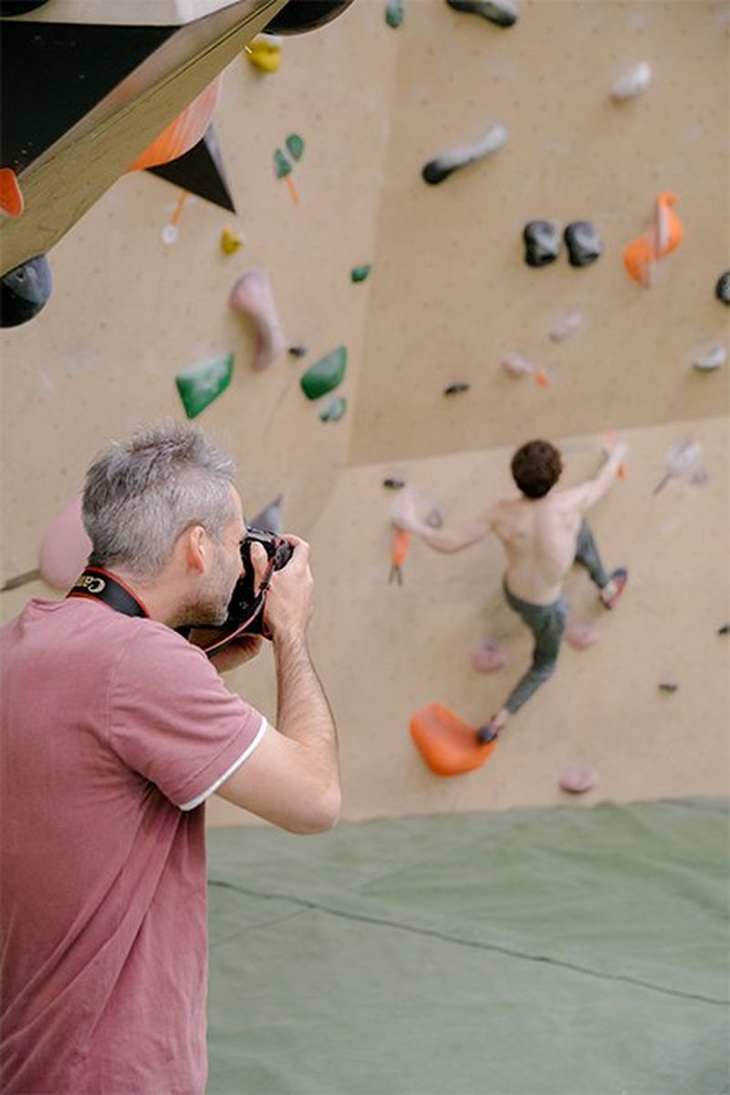 Julian Finney photographs climber Declan Rounthwaite beginning to scale a wall without a rope or harness.