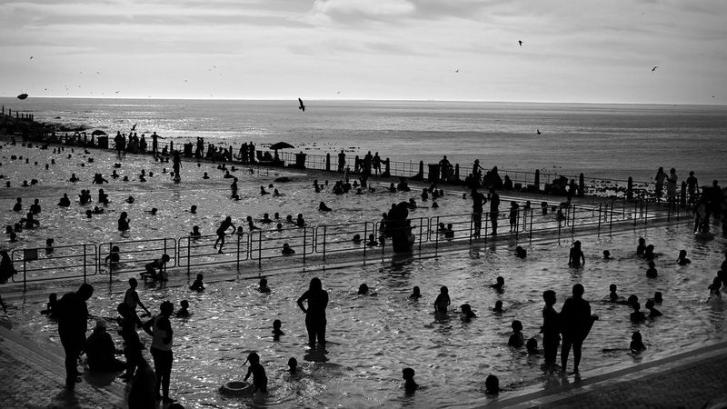 A black-and-white image from Kim Ludbrook's Contre-Jour retrospective of bathers in silhouette at Sea Point swimming pool in Cape Town, South Africa.