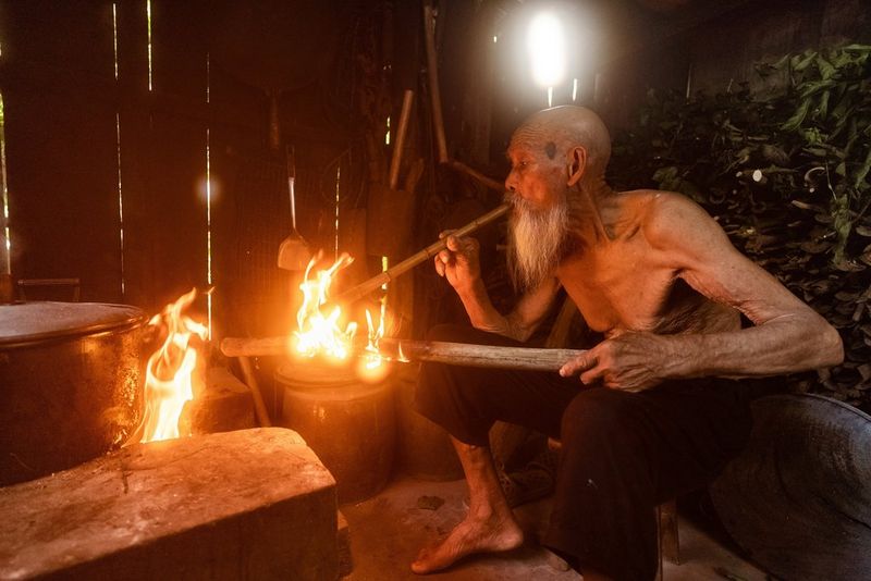 Inside his house, one of the fishermen lights a fire. Taken by Joel Santos on a Canon EOS 5D Mark IV.
