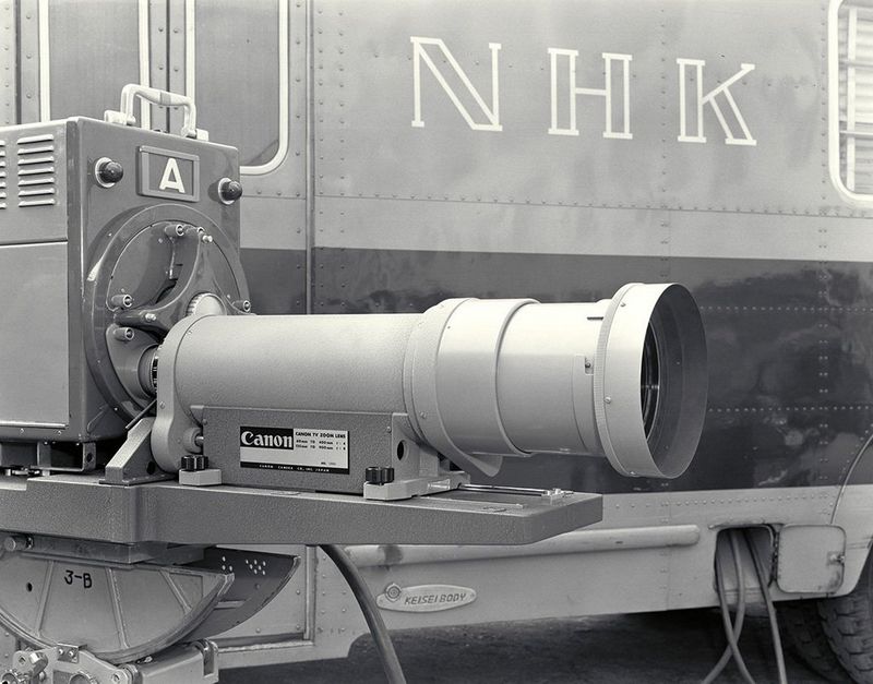 A range of Canon pro video lenses sit against a black and red background.