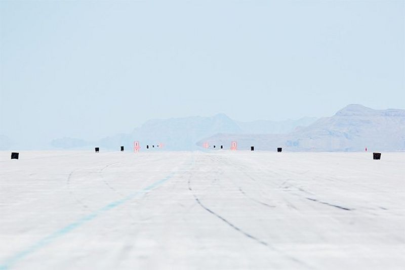 Distant markers and a blue line on the ground mark the Speedway course.