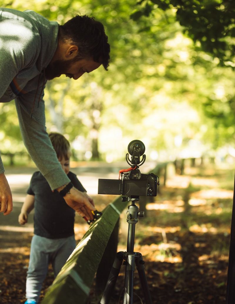 Stefan setting up his camera along a fence with his son. 