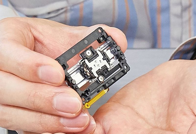 A close-up of a Nano USM unit held by one of the developers.