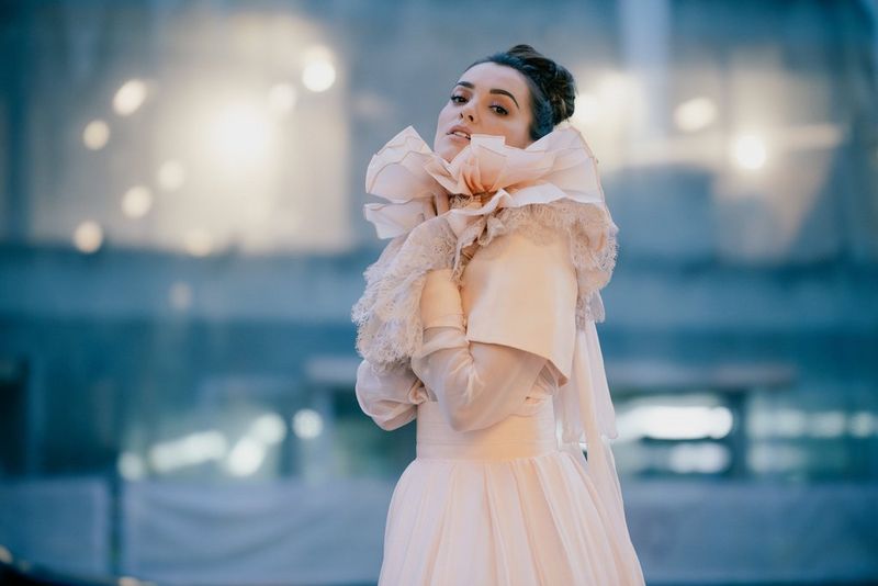 A model in a cream-coloured wedding dress against an out-of-focus background with creamier bokeh.
