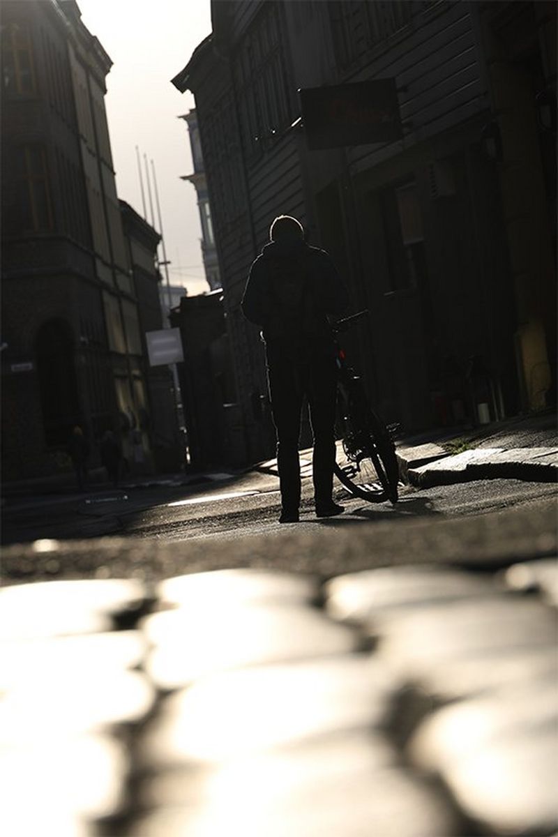 A street-level shot of a person with a bike, taken with a Canon RF 24-240mm F4-6.3 IS USM lens.