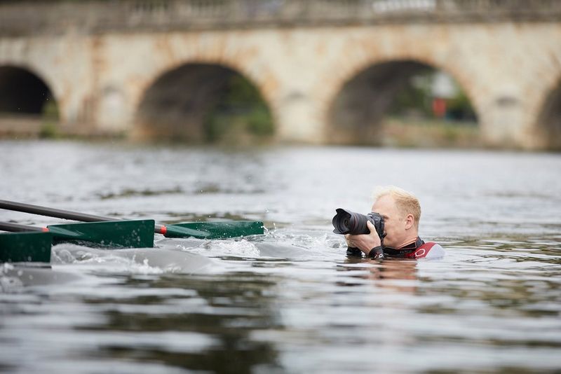Matthew Joseph in the water up to his neck, his head and camera level with the boat.