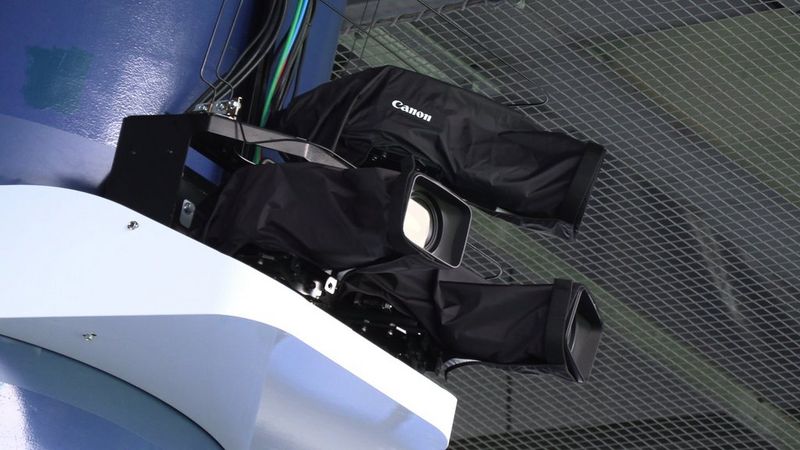 A high-level installation of three Canon Cinema EOS cameras, with weatherproof protective covers, viewed from underneath.