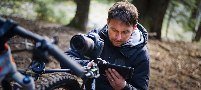 Photographer Samo Vidic, on a sports shoot, checks the back of a DSLR.
