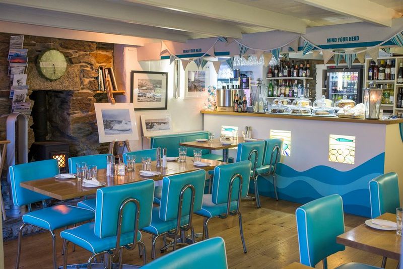 A restaurant with large, framed photo prints on display on a wall and on an easel.