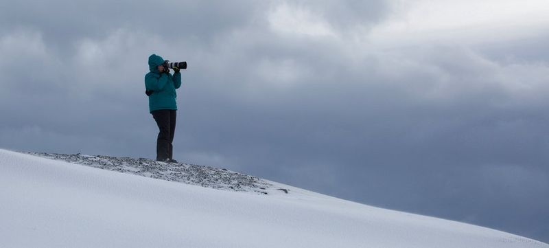 Coastal landscape photographer Carla Regler stands on a beach with a Canon camera on a tripod. Photo by Dave Griffiths.