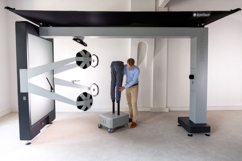 A man wheels a set of mannequin legs into a StyleShoots Vertical photography rig.