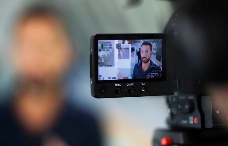 An overhead shot of photojournalism students at Visa pour l'Image assessing their portfolios.